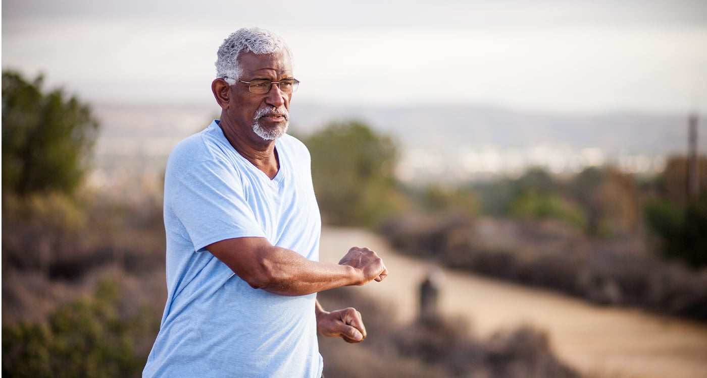 man stretching while on a hike