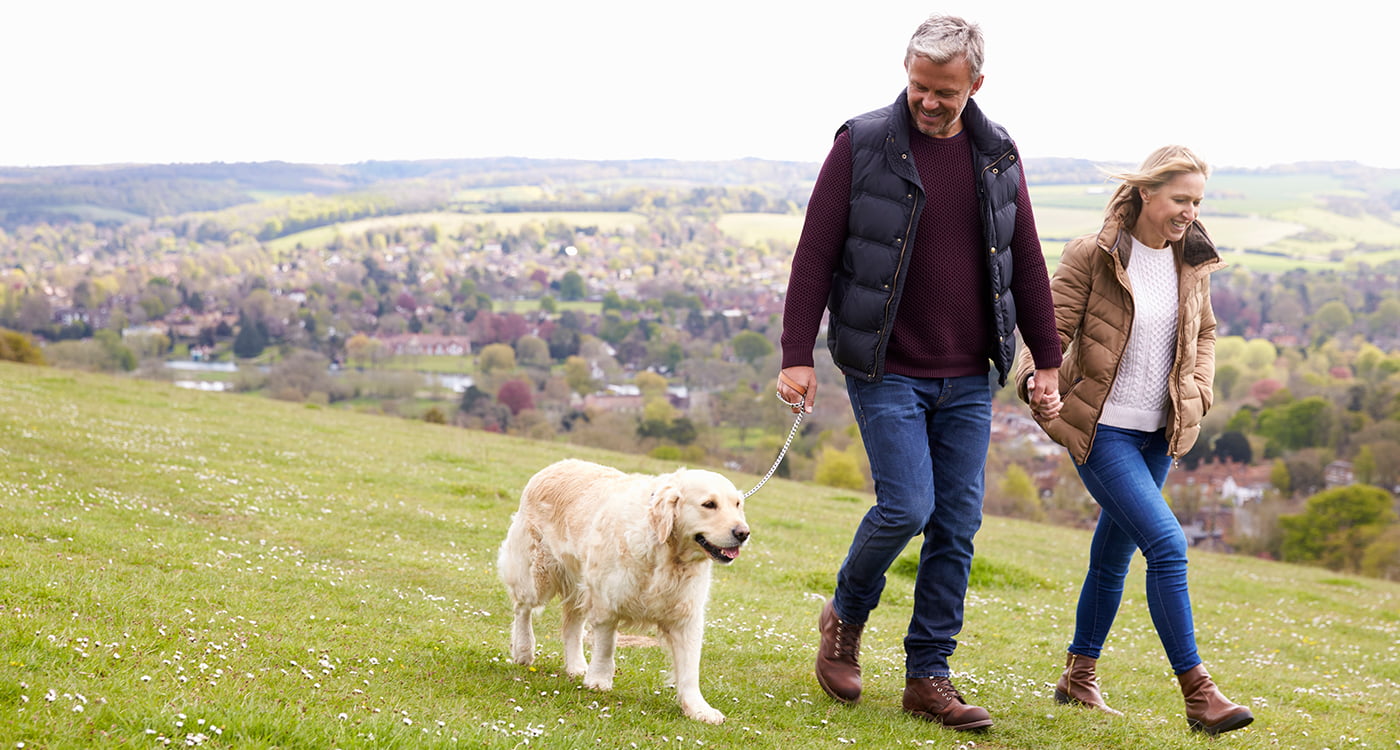 a man and a lady walking their dog